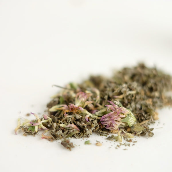 A close up of an organic herbal tea that is a tonifying women's health tonic featuring red raspberry leaf, red clover, and ginger. This tea is called Moon Medicine.