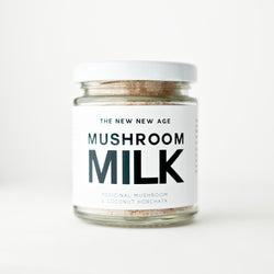 A jar of an organic herbal powder instant beverage, formulated by The New New Age. Mushroom Milk is a delicious blend of dehydrated organic coconut milk and 6 medicinal mushroom extract powders (chaga and reishi dual extract, lions mane, maitake, cordyceps, and turkey tail). Mushroom Milk is a creamy, nourishing instant beverage with immune and adaptogenic support.